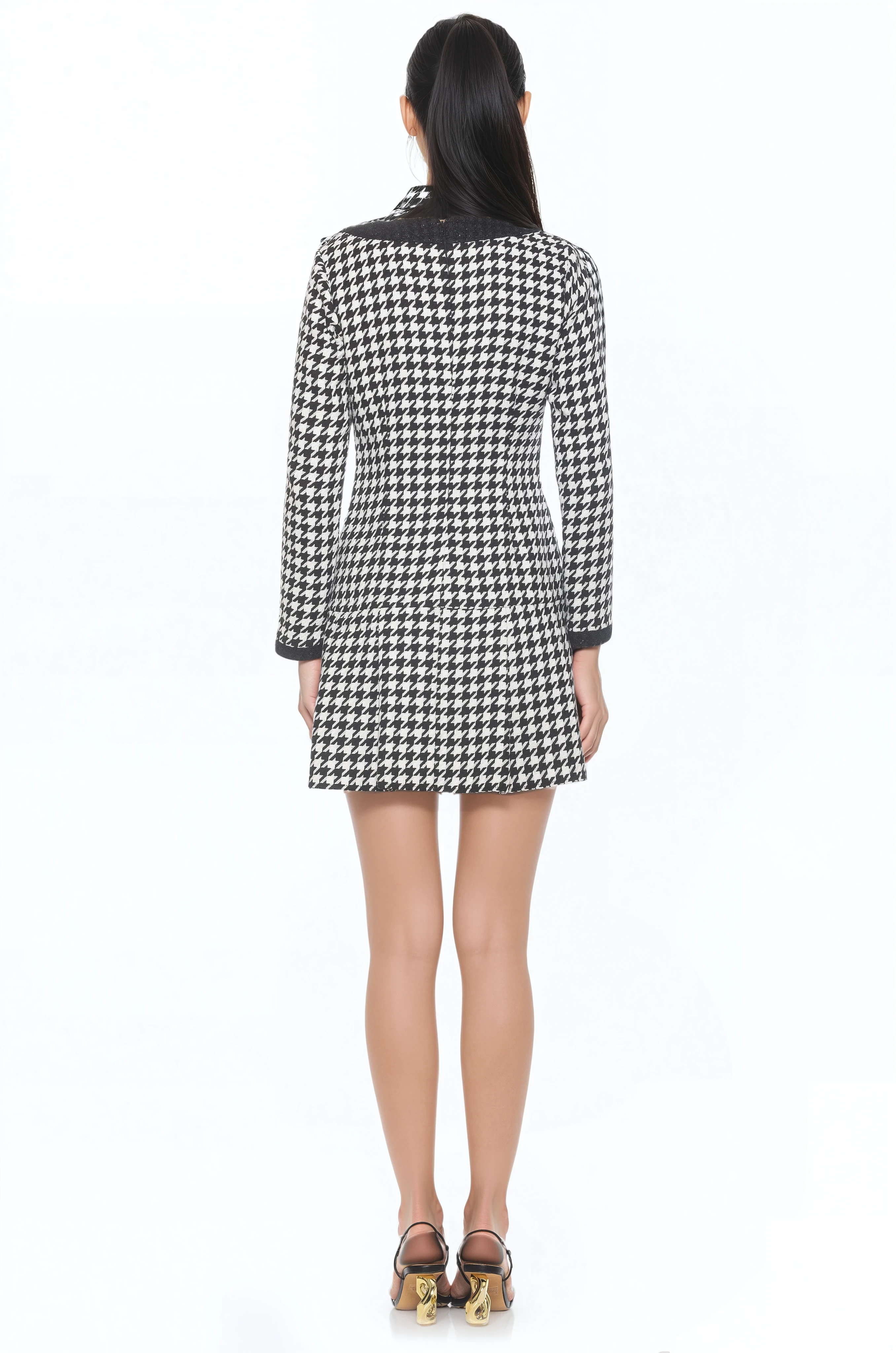 Front view black and white houndstooth mini dress, scoop neck, contrast black detail, back zip drop waist and pleated skirt.