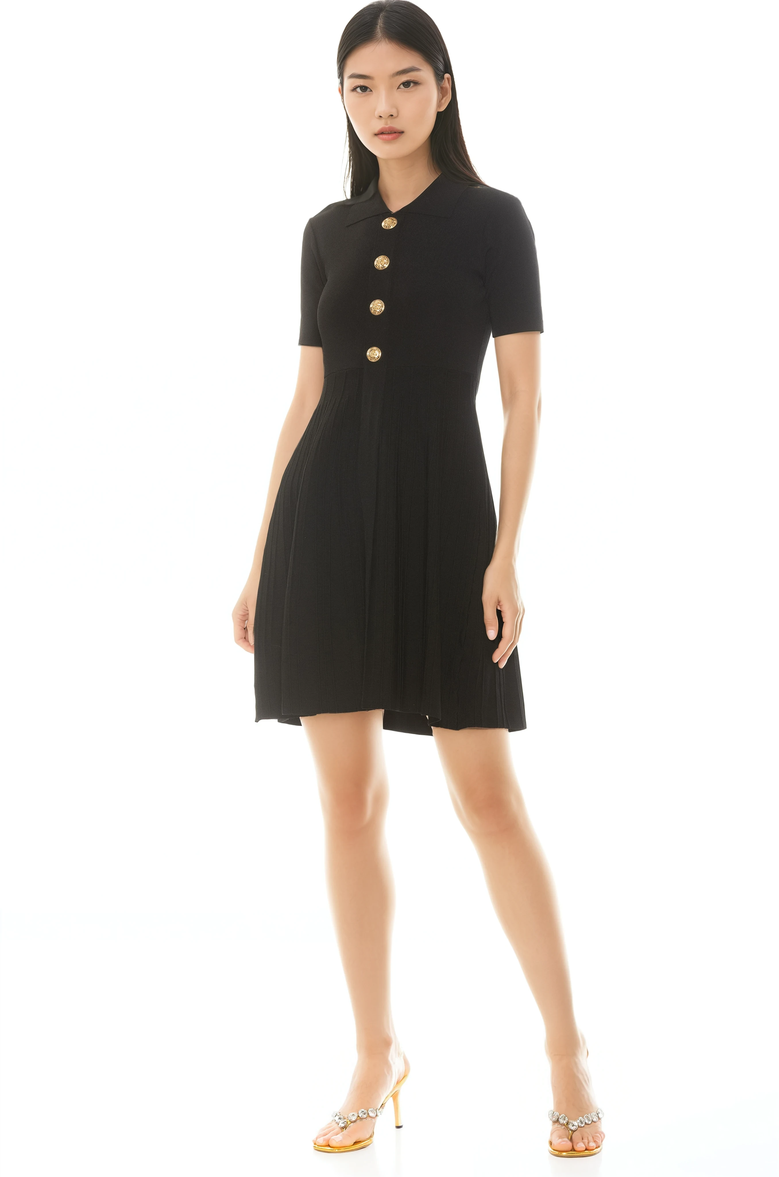 Front view black knit dress, short sleeves, knit collar, gold buttons and pleated skirt.