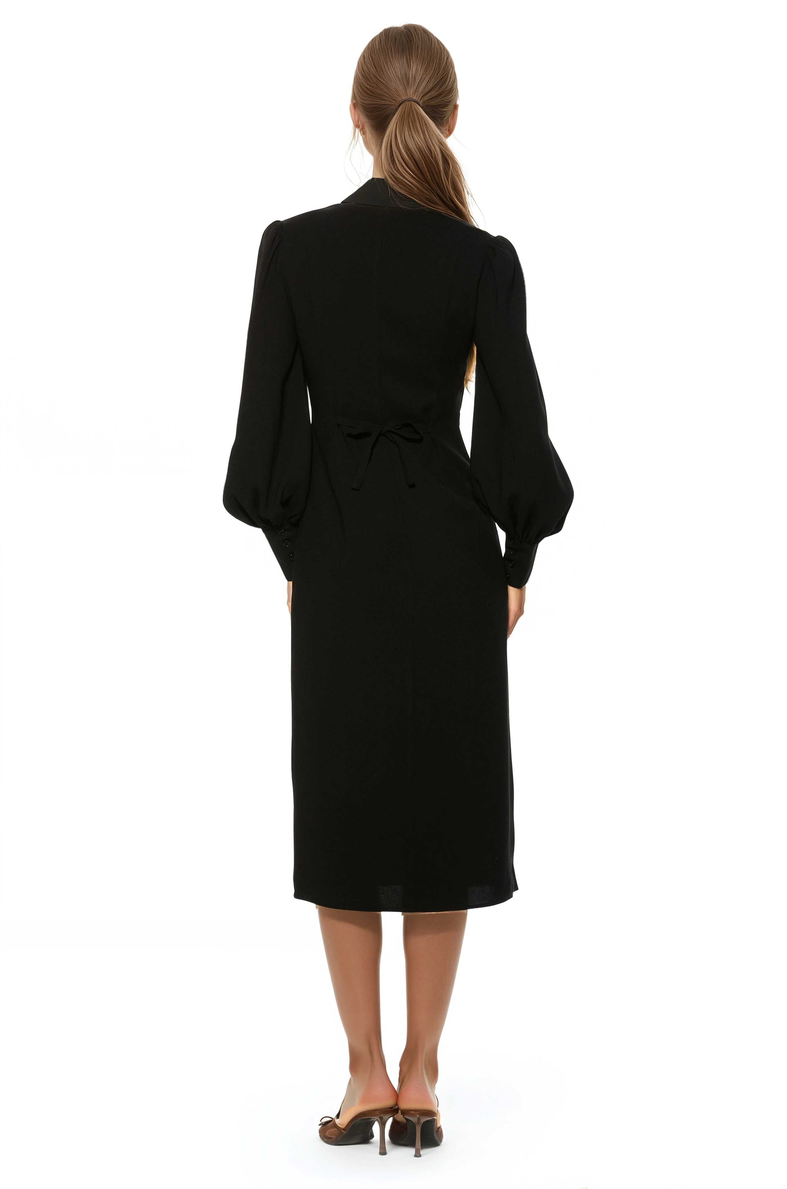 Back view black midi dress with v-neck, adjustable tie back, blouson sleeves with button cuffs.