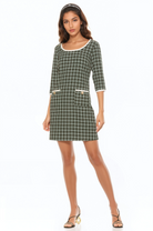 Front view green plaid mini dress, scoop neck, 3/4 sleeve, contrast ivory binding and gold buttons at pockets.