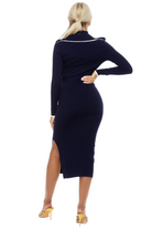 Back view navy midi dress, long sleeves, surplice neck, ivory contract detail, side slit.