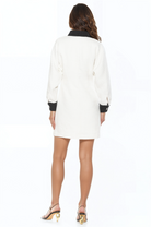 Back view ivory tweed mini dress, long sleeves, contrast black collar and cuffs, gold rimmed ivory button front.