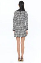 Front view black and white houndstooth mini dress, scoop neck, contrast black detail, back zip drop waist and pleated skirt.