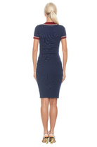 Back view navy v-neck knit dress, short sleeve, contrast red and ivory trim.