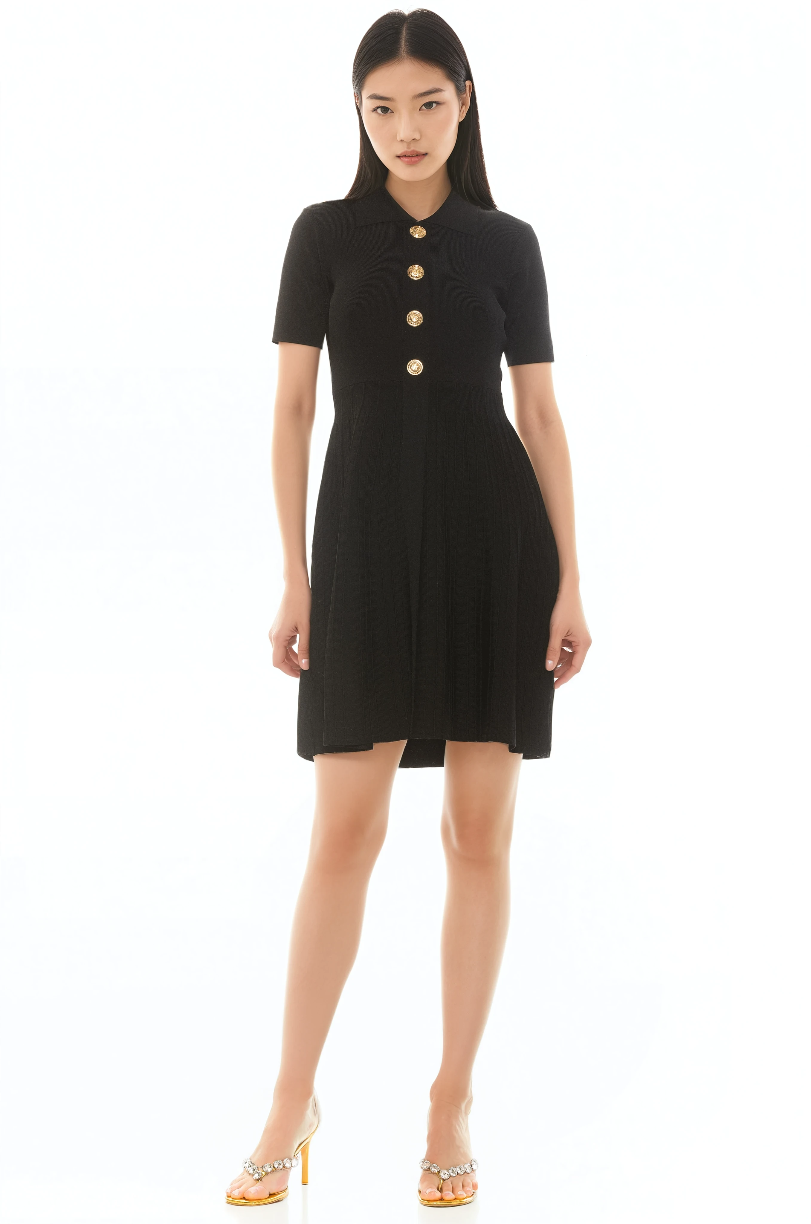 Front view black knit dress, short sleeves, knit collar, gold buttons and pleated skirt.