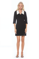 Front view black shift dress, 3/4 sleeve button front with contrast white dropped collar and flap pockets.