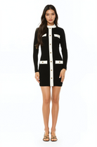 Front view black long sleeve knit mini dress, crew neck with white contrast detail and mock gold snap buttons.