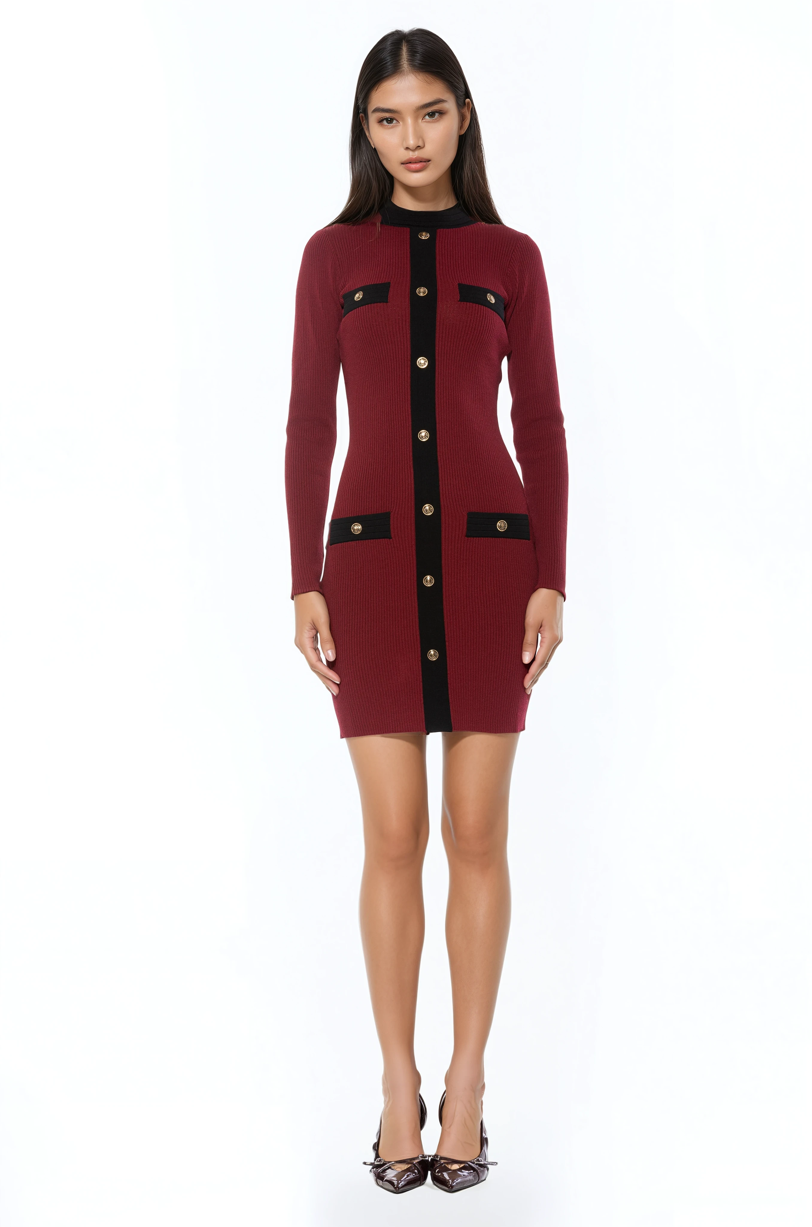 Front view burgundy long sleeve knit mini dress, crew neck with black contrast detail and mock gold snap buttons.