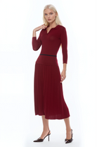 Front view burgundy knit  midi dress with drop waist, contrast black detail, pleated bottom, knit collar and 3/4 sleeves.