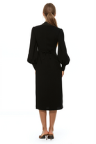 Back view black midi dress with v-neck, adjustable tie back, blouson sleeves with button cuffs.