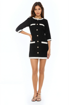 Front view black tweed button front mini shift dress,  3/4 sleeve, ivory contrast pockets and hems, pearl and gold rim buttons.