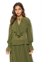 Front view green ruffle blouse, v-neck front neck tie, blouson sleeve with smocked ruffle cuff.