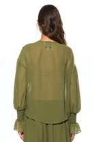 Back view green ruffle blouse, shirt tail hem, blouson sleeve with smocked ruffle cuff.